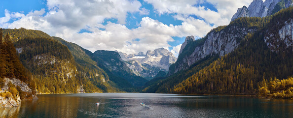 Scenic autumn panorama of Lake Gosausee with tourist boats and the Dachstein massif in the background, Austria. © T.Dz