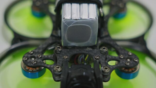 Close-up shot of FPV drone propellers spinning up during motor startup. Detailed rotor acceleration, electronic activation and preflight preparation on surface. High quality 4k footage