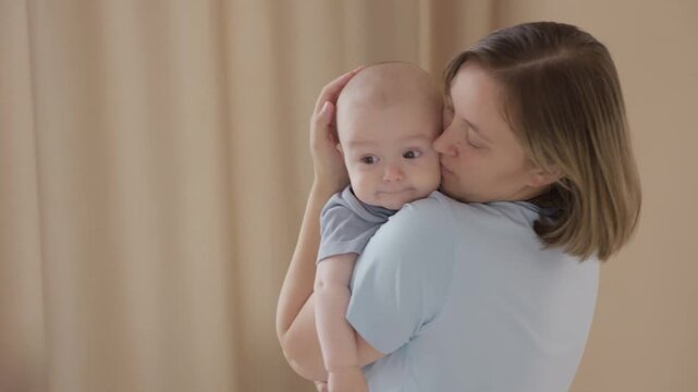 Caucasian mother soothes infant with hug at chest, calming heartbeat, forehead rest, slow breathing, quiet curtain backdrop, protective hold, sleepy relaxation