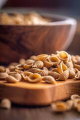 Wholegrain conchiglie pasta on wooden table.