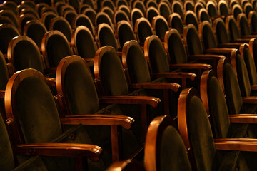 Naklejka premium Empty Classic Theater Auditorium with Rows of Velvet Seats and Wooden Armrests