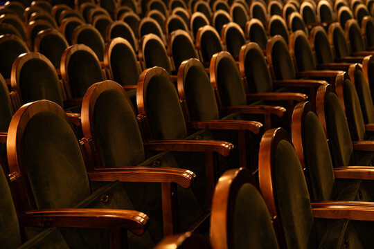 Empty Classic Theater Auditorium with Rows of Velvet Seats and Wooden Armrests