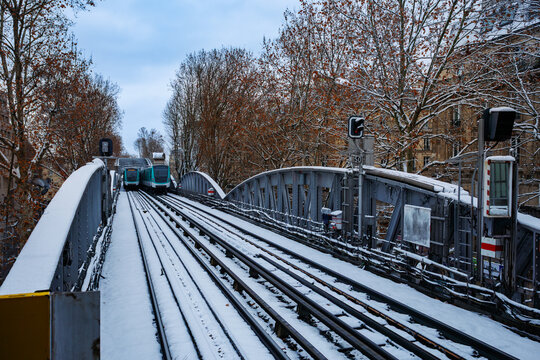 Snow-covered train tracks on a bridge in winter landscape, Paris