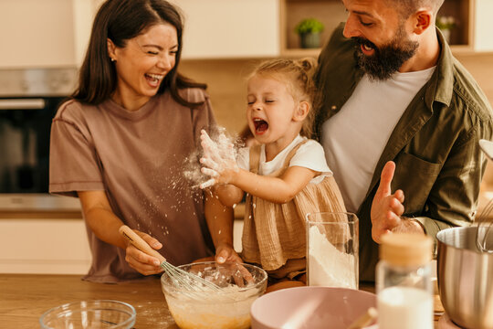 Family having fun baking, child playing with flour