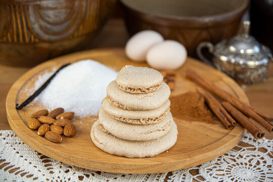 Traditional stacked almond cookies with baking ingredients, cinnamon, vanilla and eggs on a rustic wooden board. K&oacute;szka (niem. Bienenkorb &ndash; pszczeli kosz).