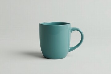 Obraz premium Simple blue mug sits on a light surface with soft shadows and clean lines during the day