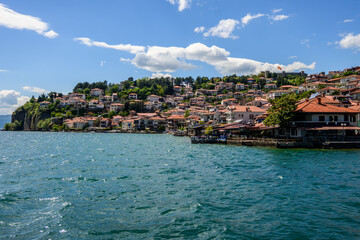 A broad perspective of Ohrid's traditional houses with terracotta roofs, clustered on a green...