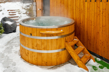 Steaming hot tub in winter garden with snow