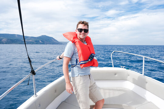 Man Enjoying a Boat Ride With Life Vest on a Sunny Day