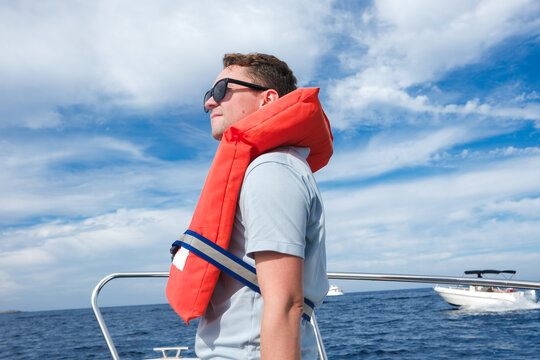 Young Man Enjoys Boating on Sunny Day Wearing Life Jacket