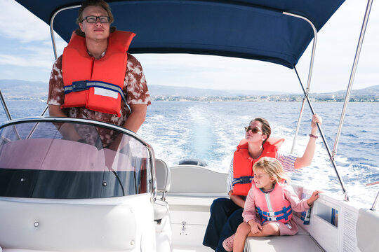 Family Enjoys a Boat Ride on a Sunny Day by the Coast