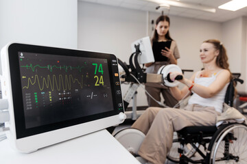 Woman training on rehabilitation bike during medical evaluation under therapist supervision....
