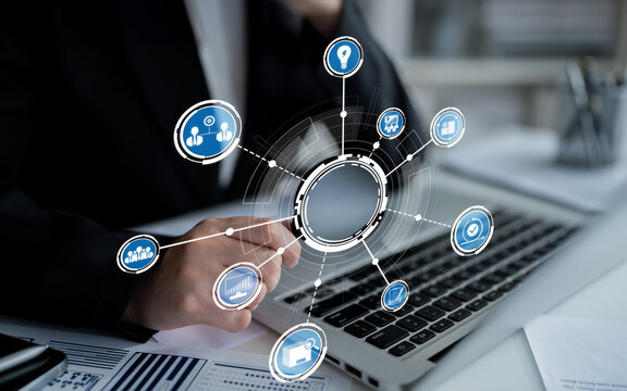 A business professional interacts with a laptop in a modern workspace, surrounded by digital icons symbolizing technology integration, data analysis, and network growth. Crux