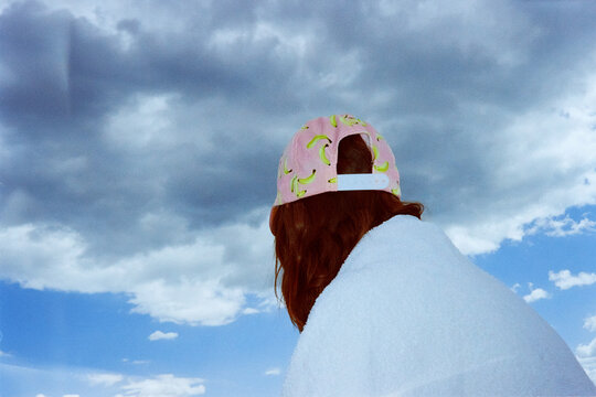 Person wrapped in towel under dramatic stormy sky