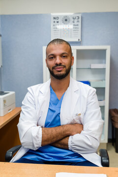 Optometrist doctor sitting in office with eye chart