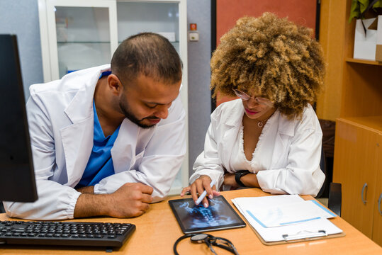 Doctors collaborating on x-ray analysis using digital tablet