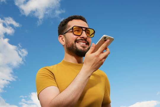 Young traveler using voice command on smartphone 