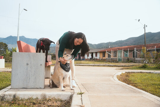 Woman petting dog in rural village park
