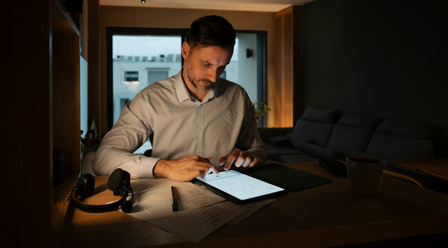 Man working late at night using tablet
