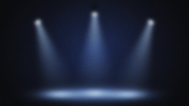 Three bright spotlights illuminating a dark stage with blue haze