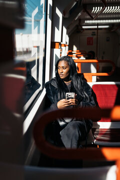 Young woman commuting by train looking out window