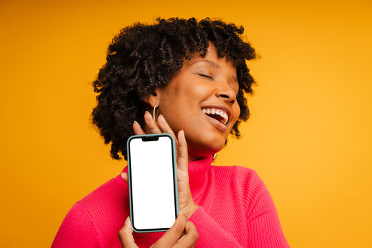 Woman in a studio, holding a mobile phone with blank screen