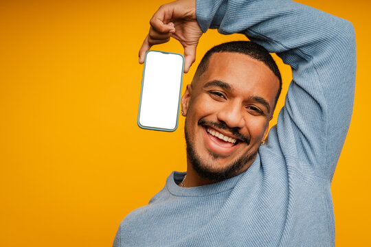 Cheerful man is posing with a mobile phone with blank screen