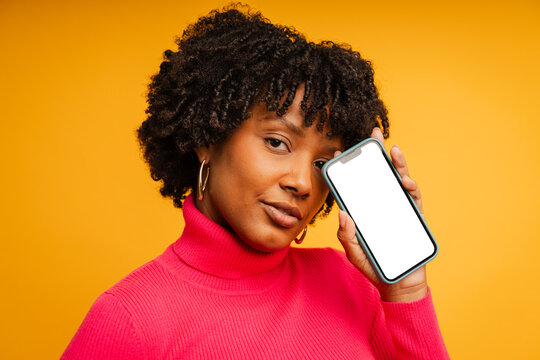Woman with a mockup phone stands in a studio