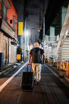 Person traveling through a Tokyo alleyway at night