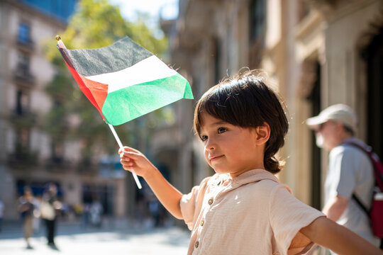 Young child with Palestinian flag in the street
