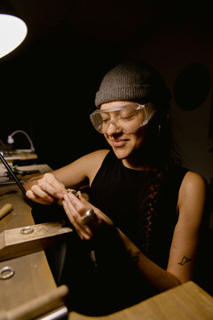 Goldsmith shaping metal with coping saw
