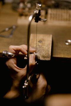 Jeweler saws at a silver ring in authentic jewellery workshop