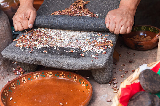 Hands Using Stone Tools to Grind Ingredients