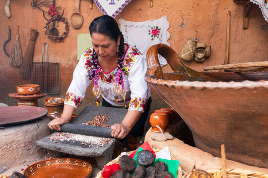 Woman Grinding cacao beans in Colorful Traditional Attire