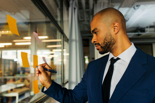 Businessman writing on sticky notes for business strategy
