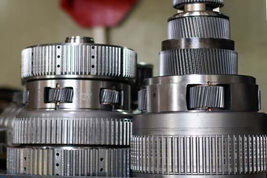 Close-up of a professional steel planetary gear set from an Allison transmission, showing the precision teeth and metallic texture during a heavy-duty gearbox maintenance in a workshop.