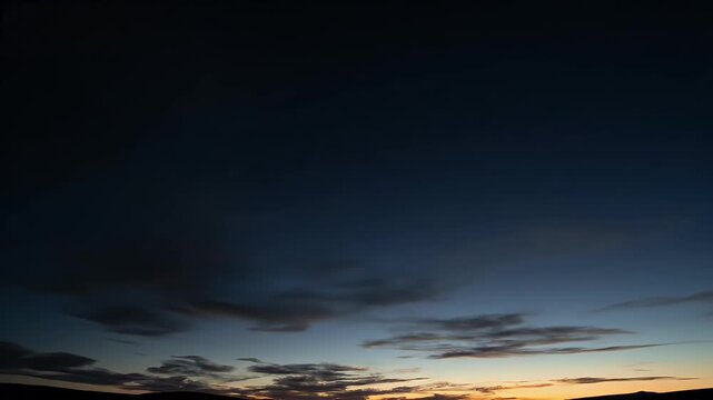 Dramatic sky at dusk with wispy clouds, gradient colors, and horizon