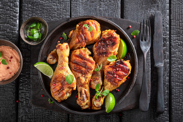 Crispy grilled chicken leg as summer delicacy in sunny day.