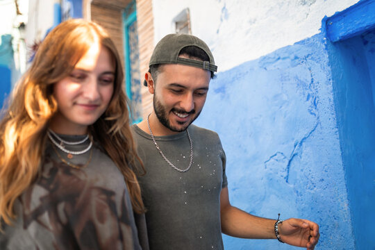 Interracial couple walking through blue streets of Chefchaouen