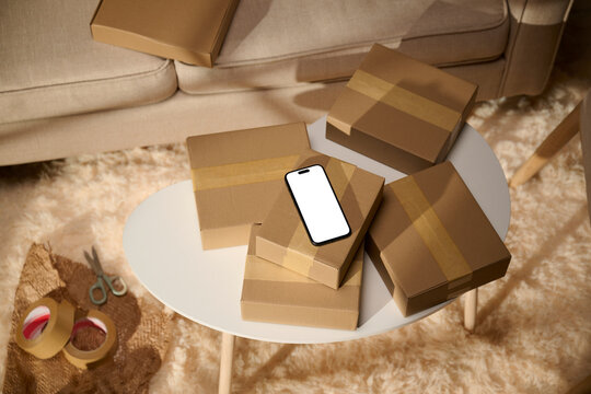 Smartphone with a blank screen on top of cardboard boxes