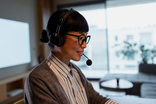 Asian woman working in call center using headset
