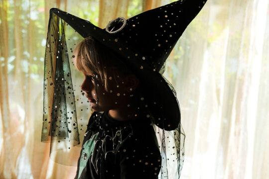 Young Child Dressed as a Witch in a Warmly Lit Room
