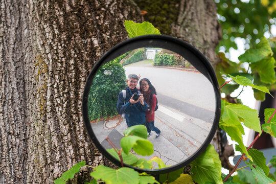 Couple Takes Mirror Selfie Outdoors Surrounded by Greenery