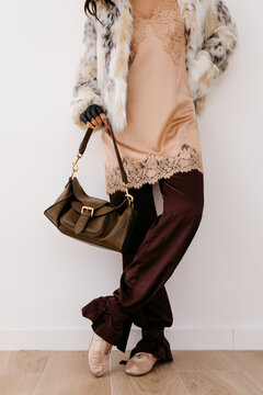 Woman wearing faux fur coat, slip dress, and ballet flats