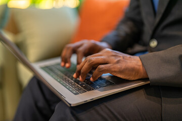 Close up of african american businessman hands typing on laptop keyboard, Professional male...