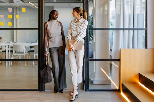 Businesswomen walking and talking in modern office