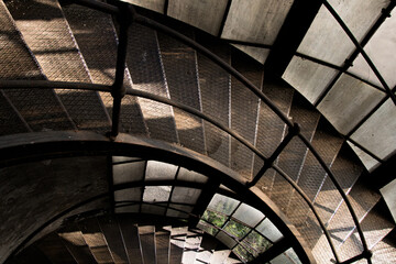 Fototapeta premium Spiral staircase with metal structure and dramatic light