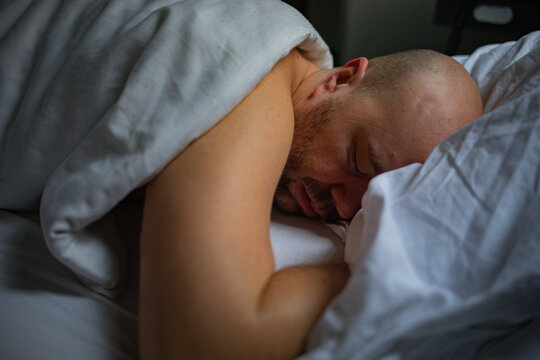 Man Sleeping Peacefully in a Cozy Bedroom Setting