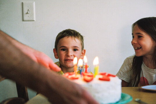 Family presents child with birthday cake at party