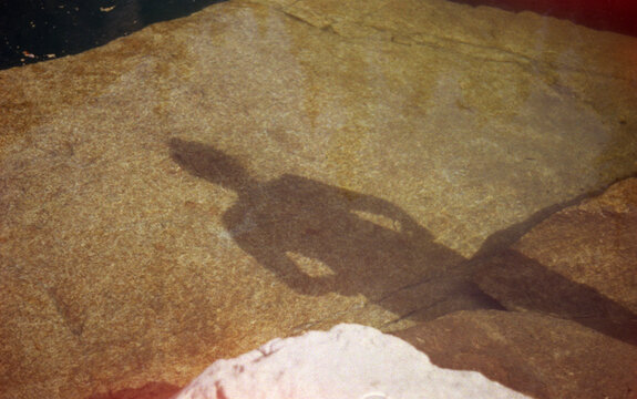 Underwater shadow through clear glacier water.